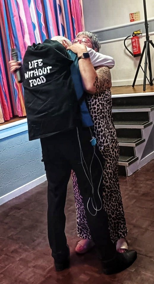 Darren Carter being hugged, wearing the Life Without Food jacket